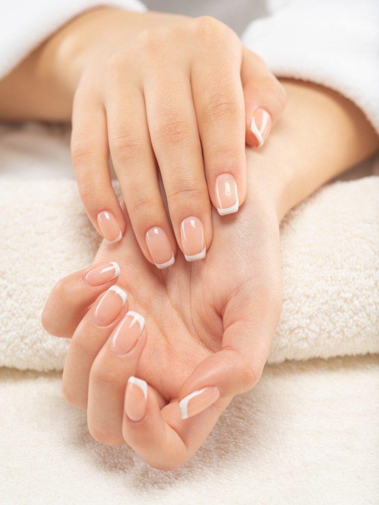 Woman gets manicure procedure in a spa salon. Beautiful female h